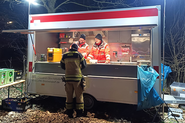 Feuerwehrmann wird am Verpflegungsanhänger betreut