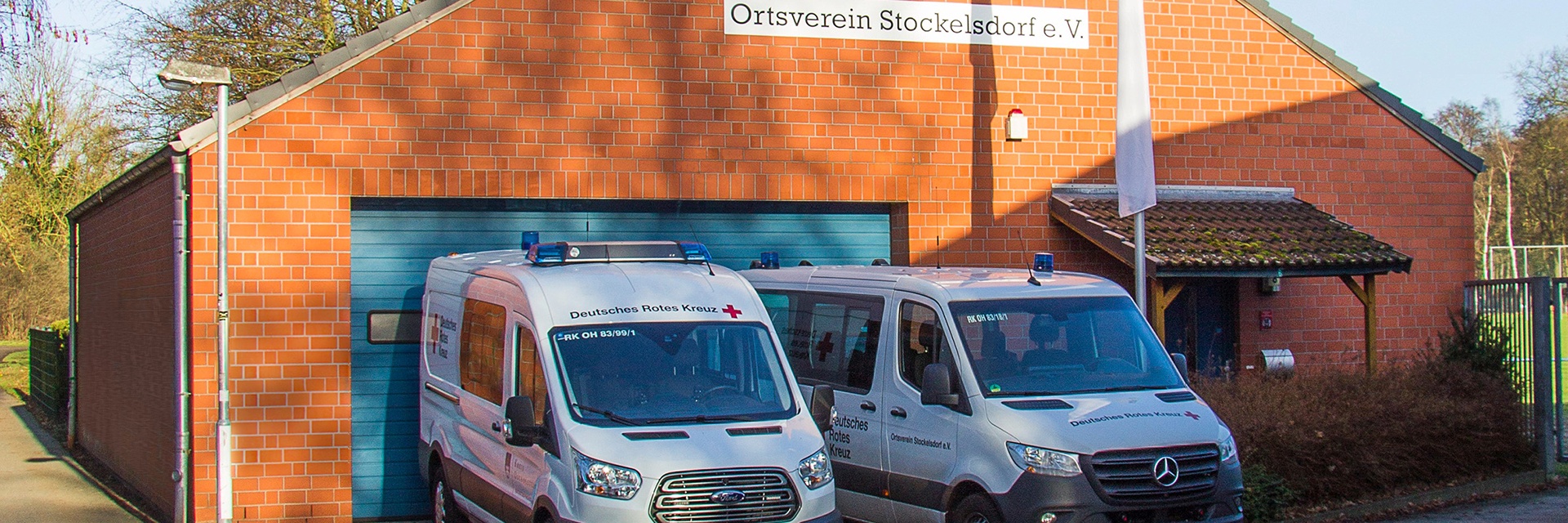 Einsatzfahrzeuge vor der DRK-Unterkunft (KI unterstützt)